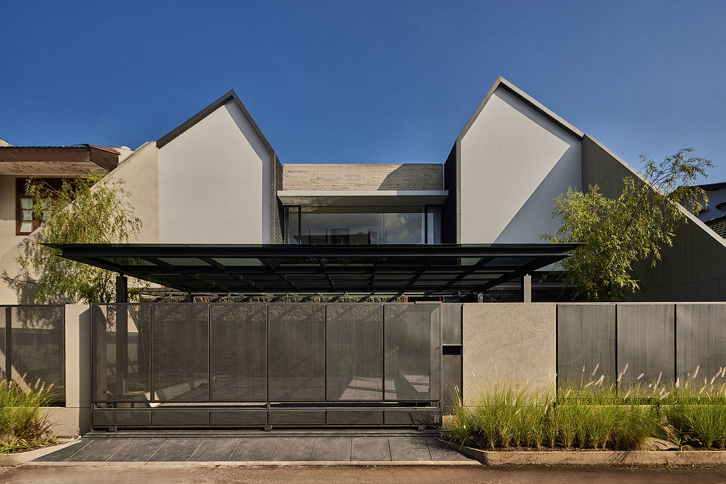 Contemporary architectural design with sleek, angular forms, glass walls, and a shaded terrace.