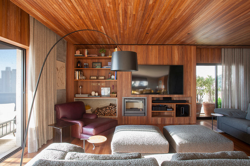 Warm, modern living space with wooden paneling, media console, and cozy seating.