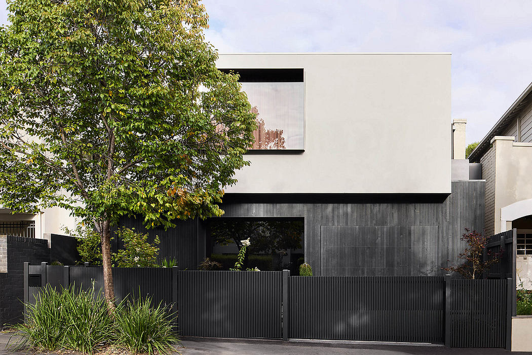 Modern minimalist home with clean lines, monochrome exterior, and lush greenery.