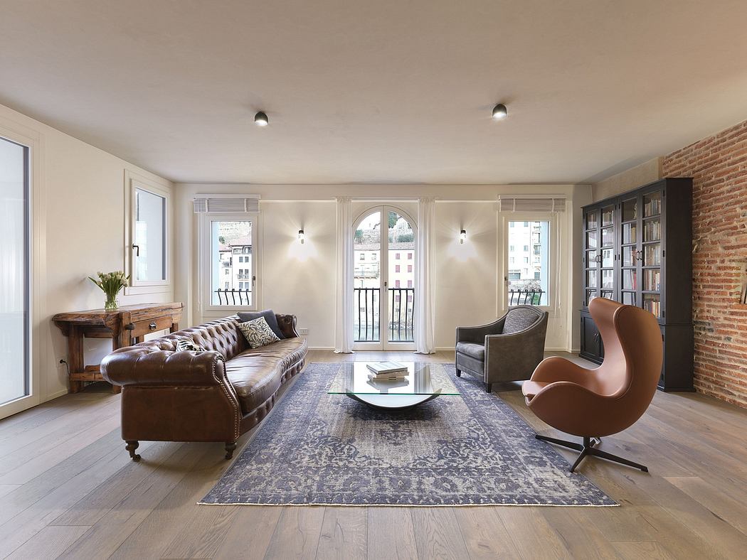 Elegant living room with arched windows, plush leather sofa, and modern armchair.