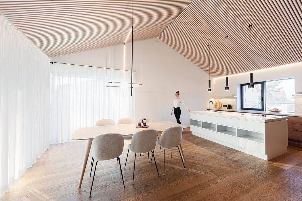 Minimalist kitchen and dining area with wooden ceiling, clean lines, and modern furniture.