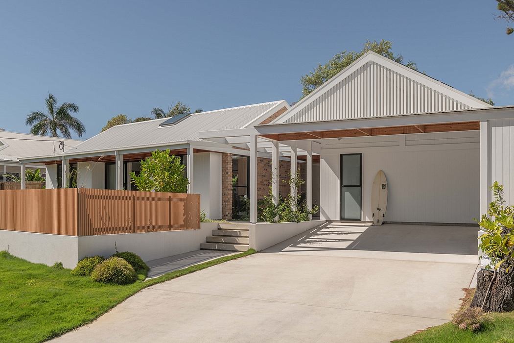 A modern, open-concept home with a white exterior, gabled roof, and wooden accents.