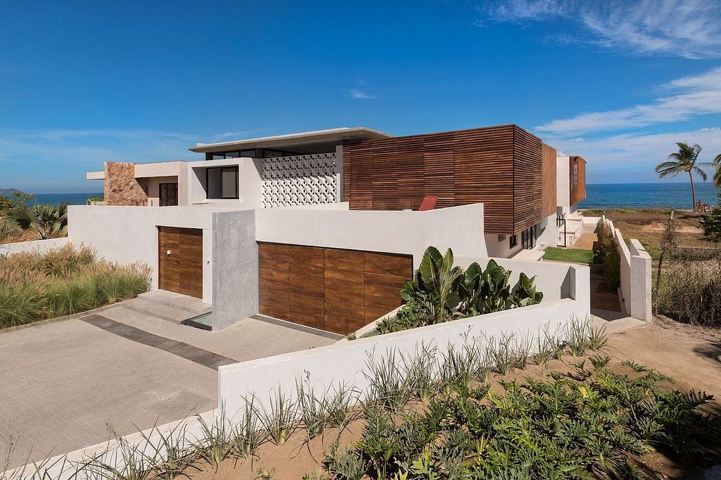 Sleek beachside villa with wooden accents, stone walls, and lush landscaping.