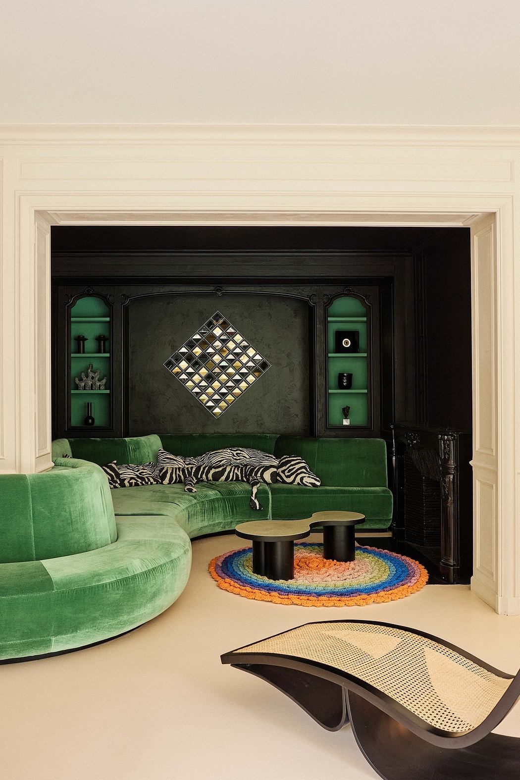 Elegant interior design with green velvet sofas, intricate wall panel, and modern round tables.