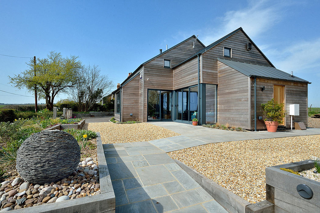 A modern, wooden-clad residence with a well-designed outdoor patio and landscaping.
