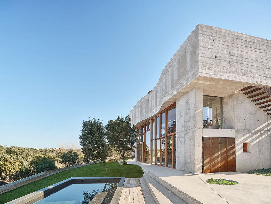 Striking modern architecture with concrete walls, large windows, and a tranquil pool.