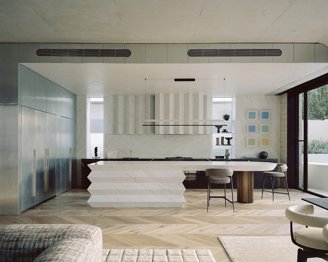 Spacious modern kitchen with sleek white cabinets, wooden floors, and minimalist furniture.