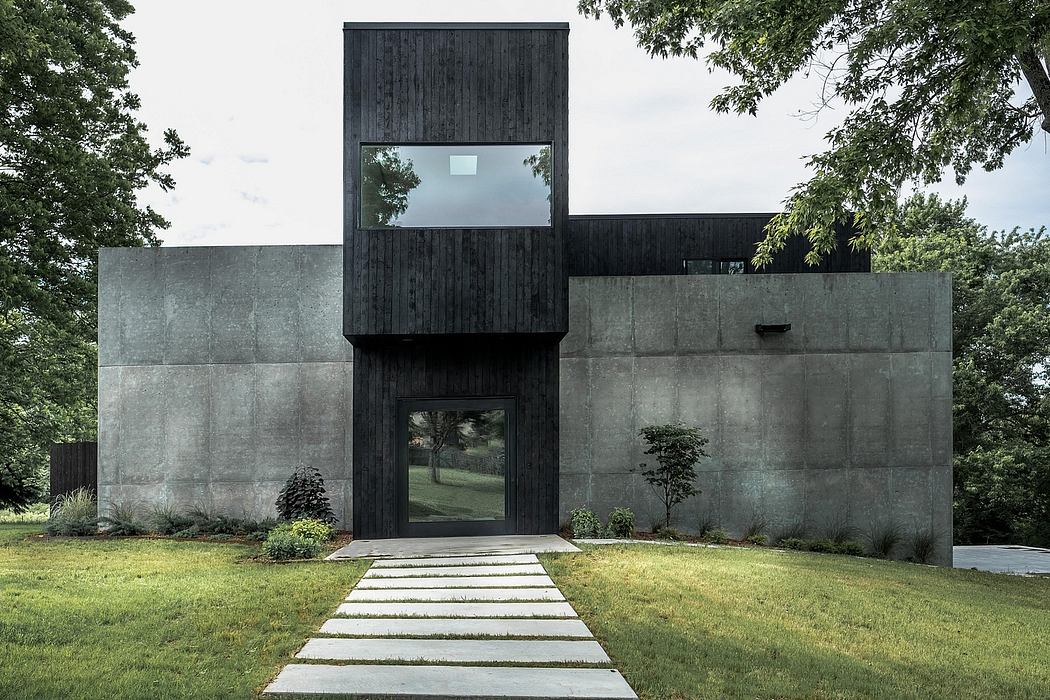 Contemporary concrete and wood exterior with geometric design and large windows overlooking greenery.