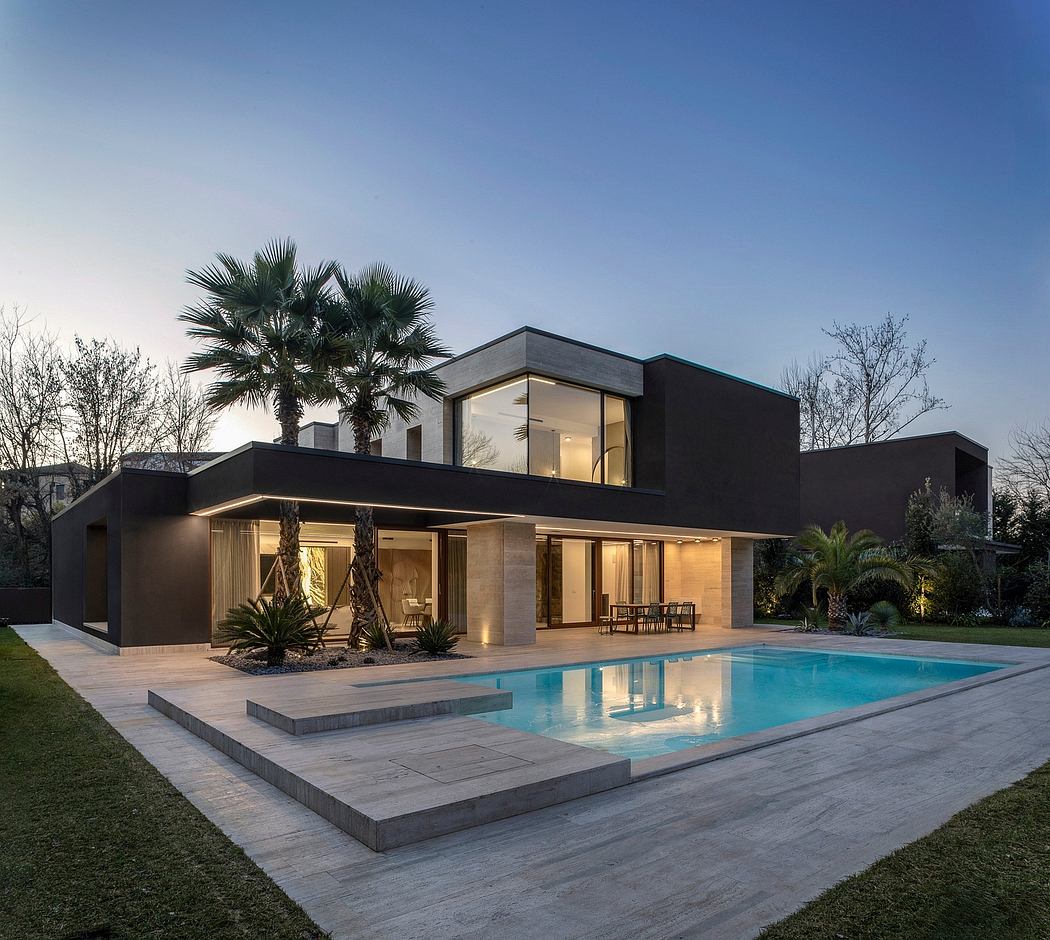 Modern, sleek home with pool, palm trees, and glass walls reflecting the night sky.