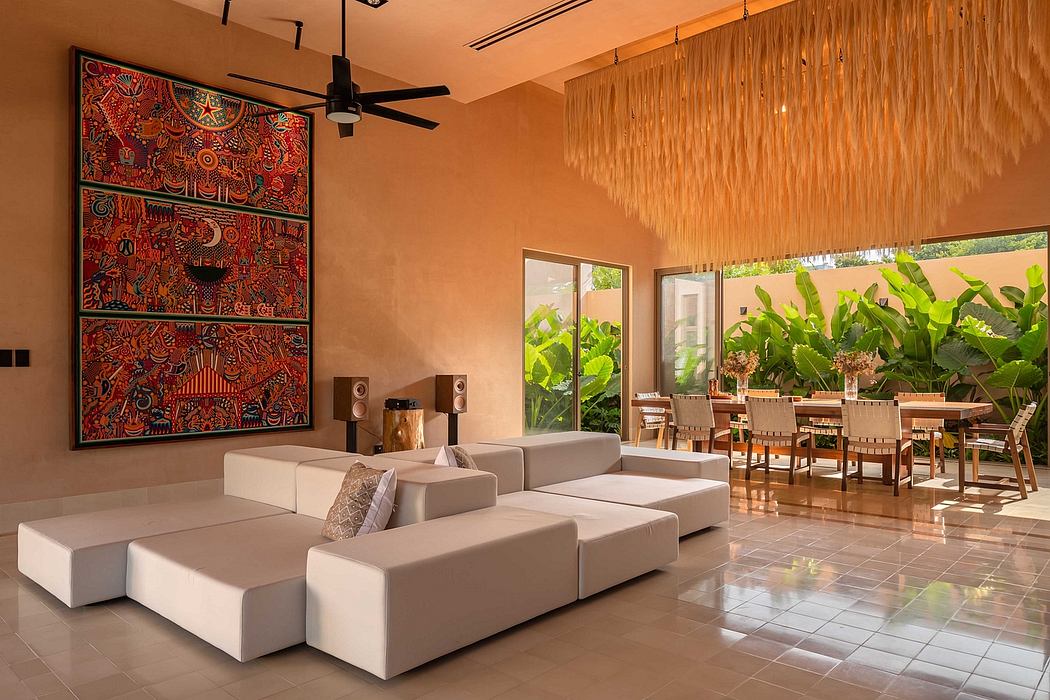 Warm-toned interior with vibrant artwork, plush seating, and views of lush greenery.