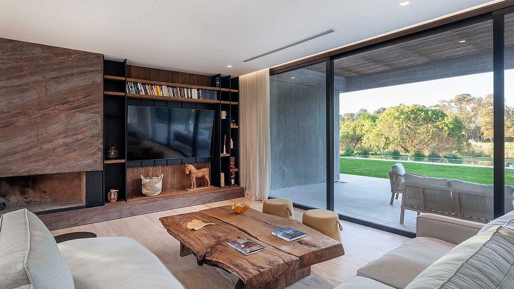 A modern living room with a wooden TV display, large windows, and a rustic wooden coffee table.