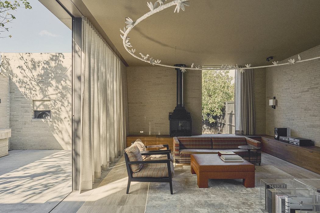 A modern living room with a sleek fireplace, large windows, and beautiful lighting fixtures.