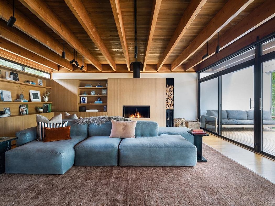 Inviting modern cabin interior with wooden beams, cozy sectional sofa, and fireplace.