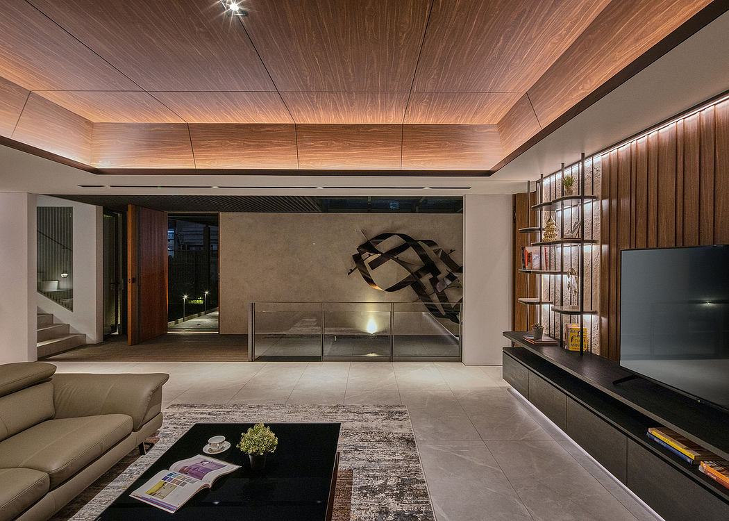 Sleek modern interior with wood paneled ceiling, glass wall, and abstract sculpture.
