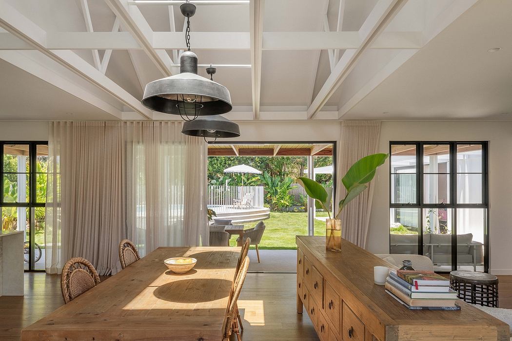 Warm, modern interiors with exposed beams, natural wood furnishings, and large windows overlooking lush greenery.