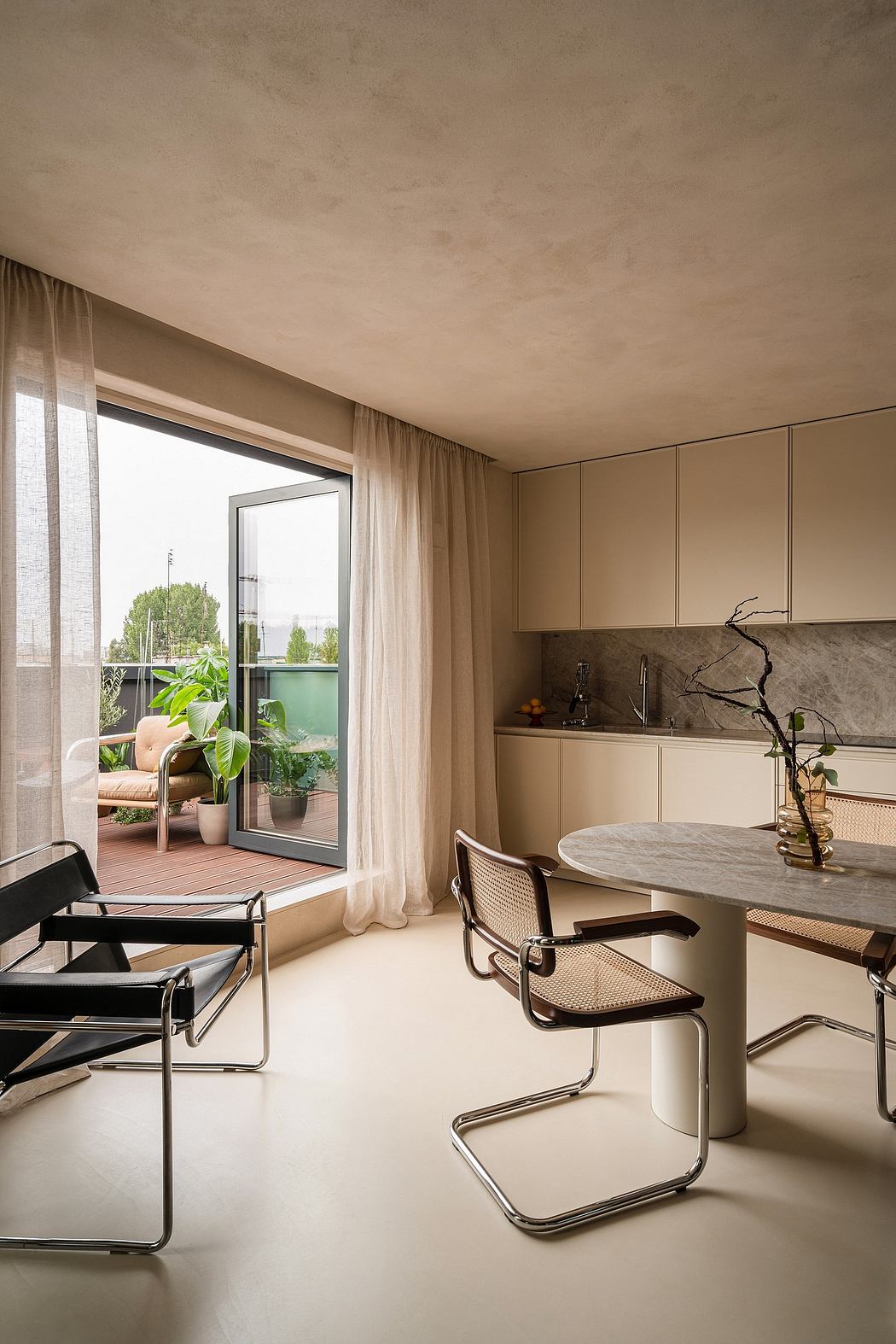 Elegant minimalist kitchen and dining area with marble table, sleek chairs, and floor-to-ceiling windows.
