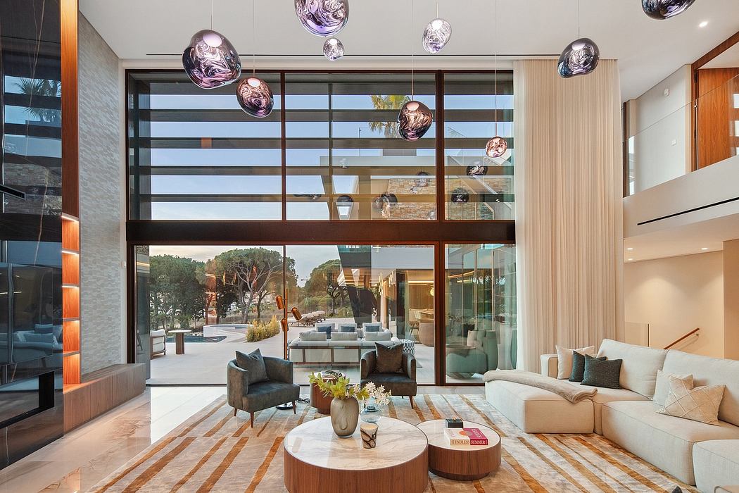 Modern open-concept living room with floor-to-ceiling windows, glass pendant lights, and contemporary furnishings.