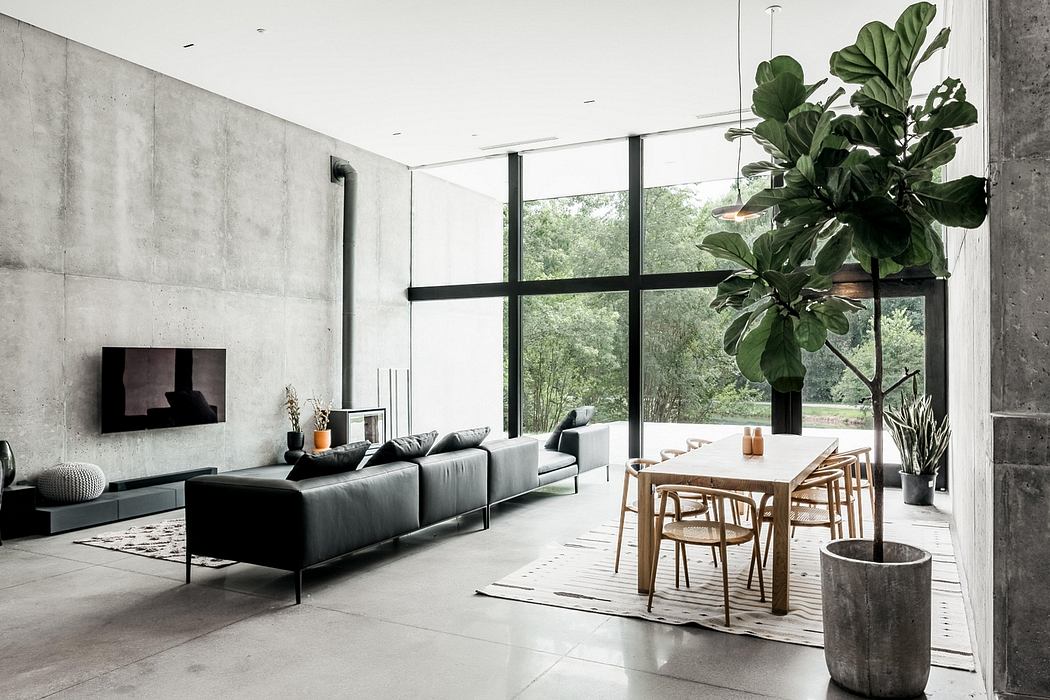 Minimalist living room with large windows, concrete walls, and natural wood furnishings.