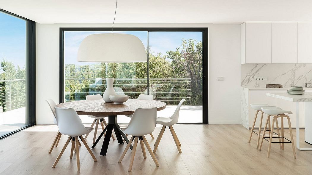 Spacious, modern dining area with large windows overlooking lush greenery.
