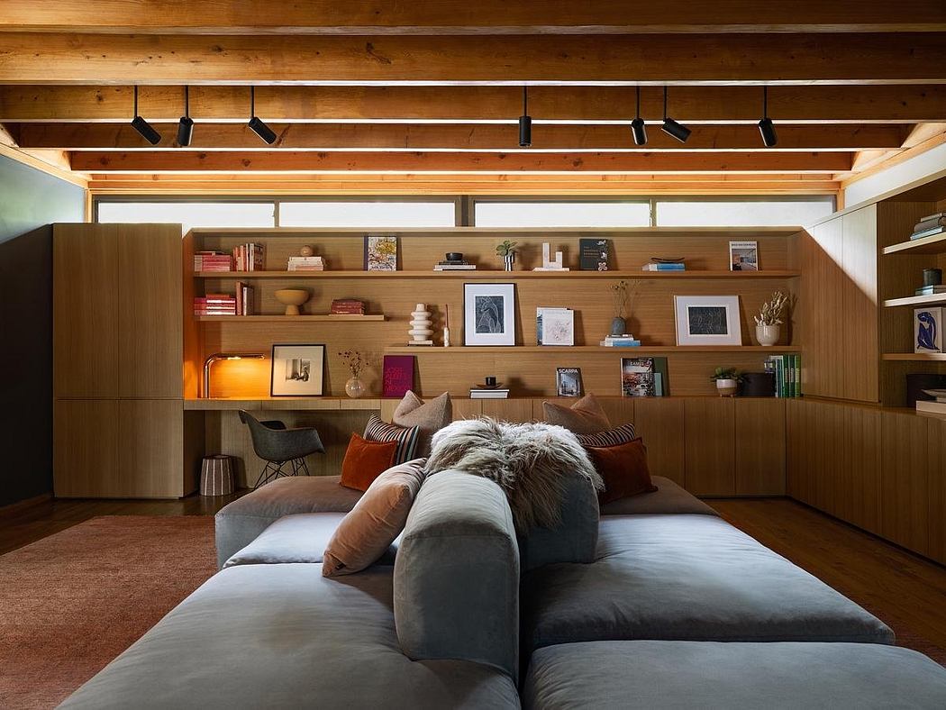 Cozy living room with wooden beams, built-in bookshelves, and warm lighting accents.