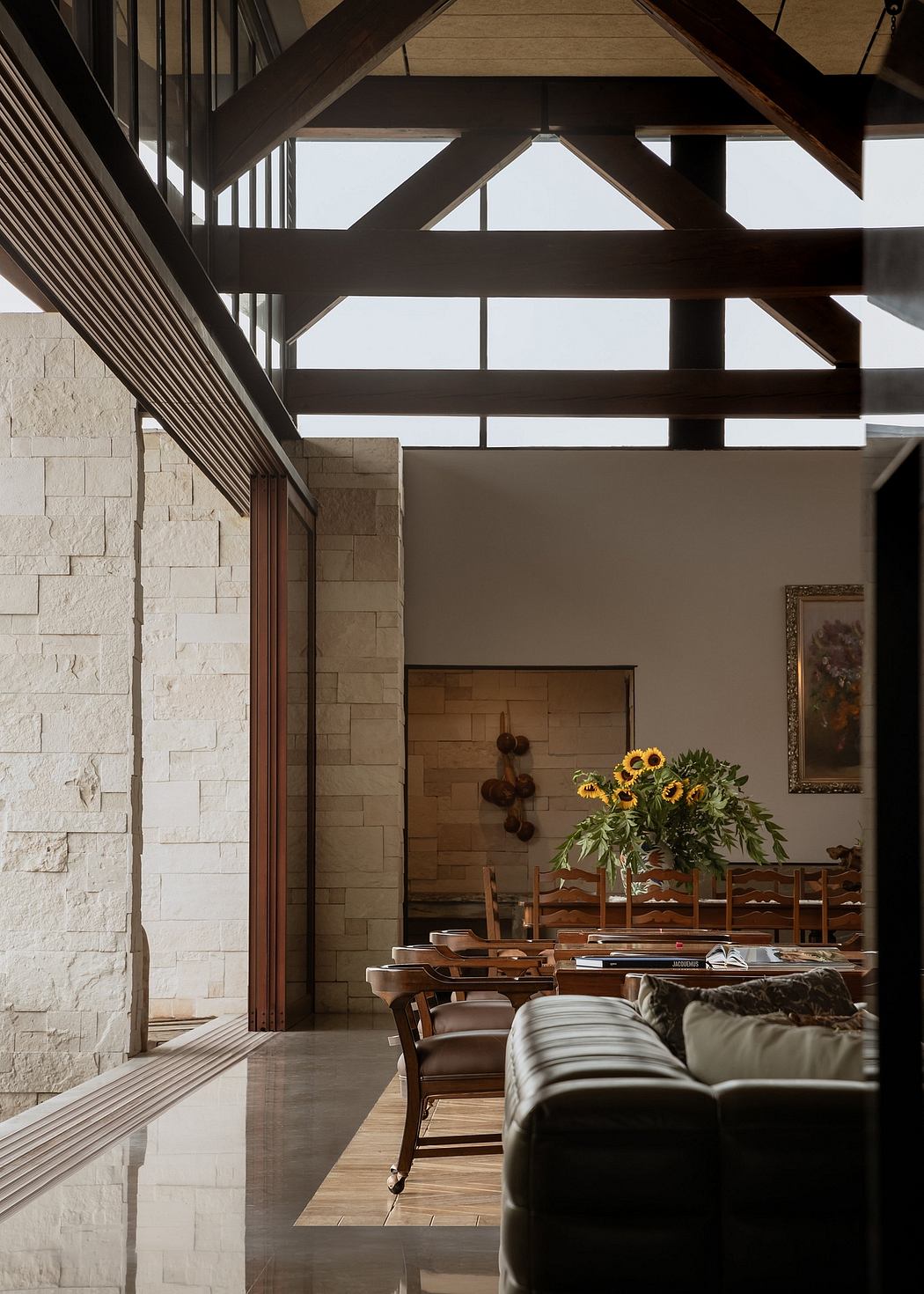 Spacious interior with wooden beams, stone walls, and a cozy seating area.