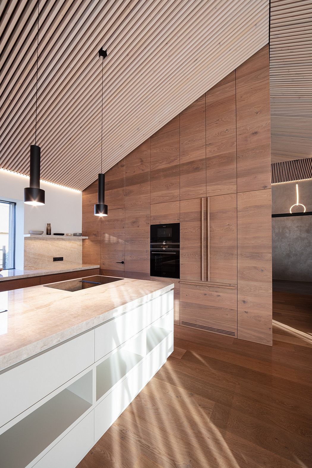 A modern kitchen with wooden paneled walls, recessed lighting, and sleek cabinetry.