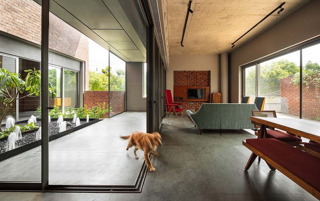 Modern open-plan interior with brick accents, large windows, and a dog wandering the space.
