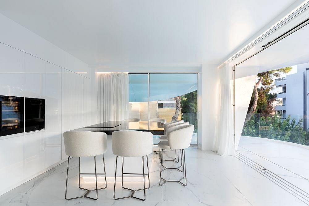 Stylish open-concept living area with minimalist furniture and floor-to-ceiling windows.