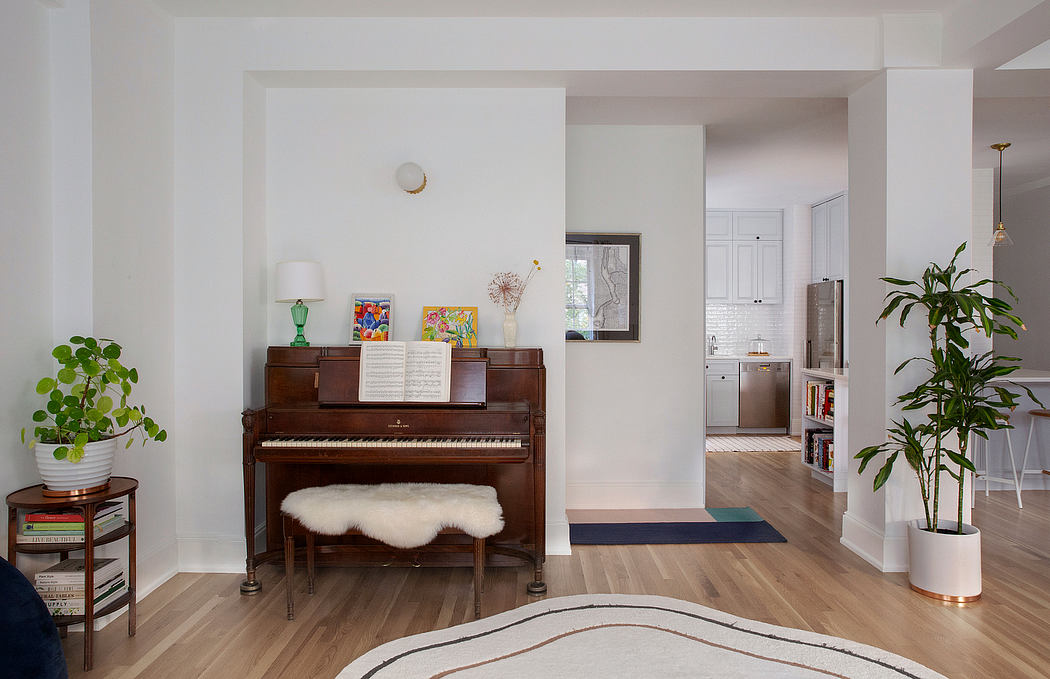 Spacious, light-filled room with wood floors, piano, and vibrant artwork.