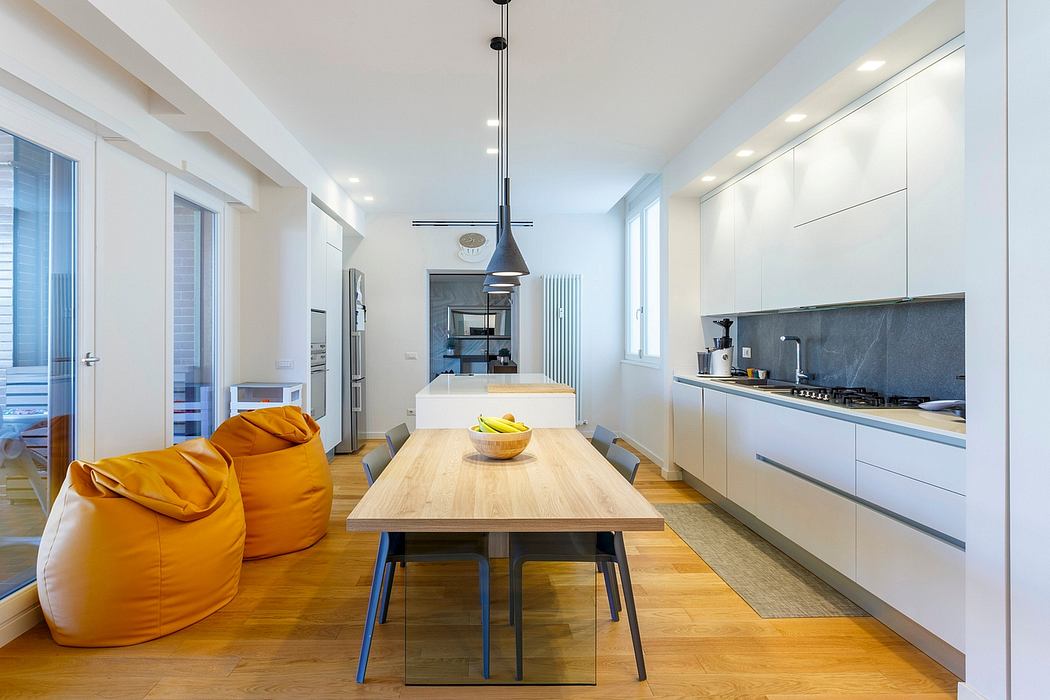 Bright, modern kitchen with wooden dining table, sleek cabinetry, and striking pendant lights.