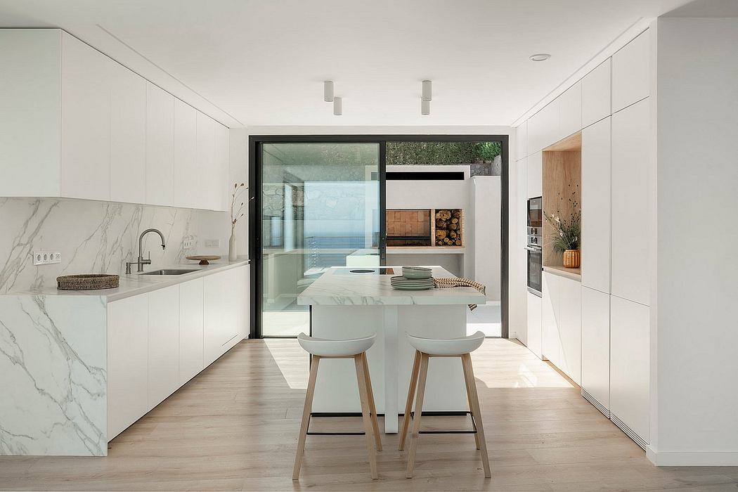 Minimalist kitchen with marble countertops, large windows, and a sleek, modern design.