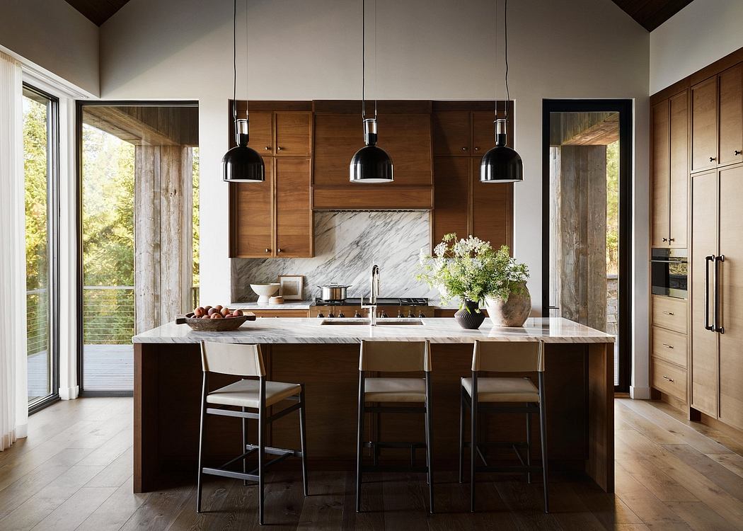 A modern kitchen with wooden cabinets, marble countertops, and pendant lighting.