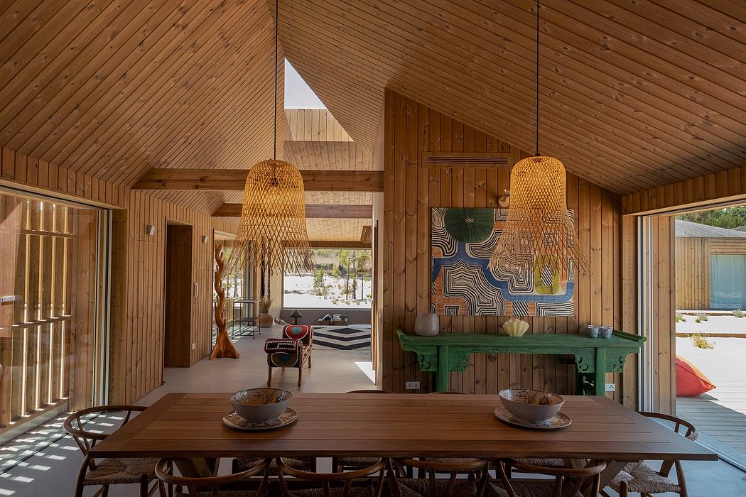 Warm, rustic wood cabin interior with geometric lighting fixtures and an eclectic mix of furnishings.