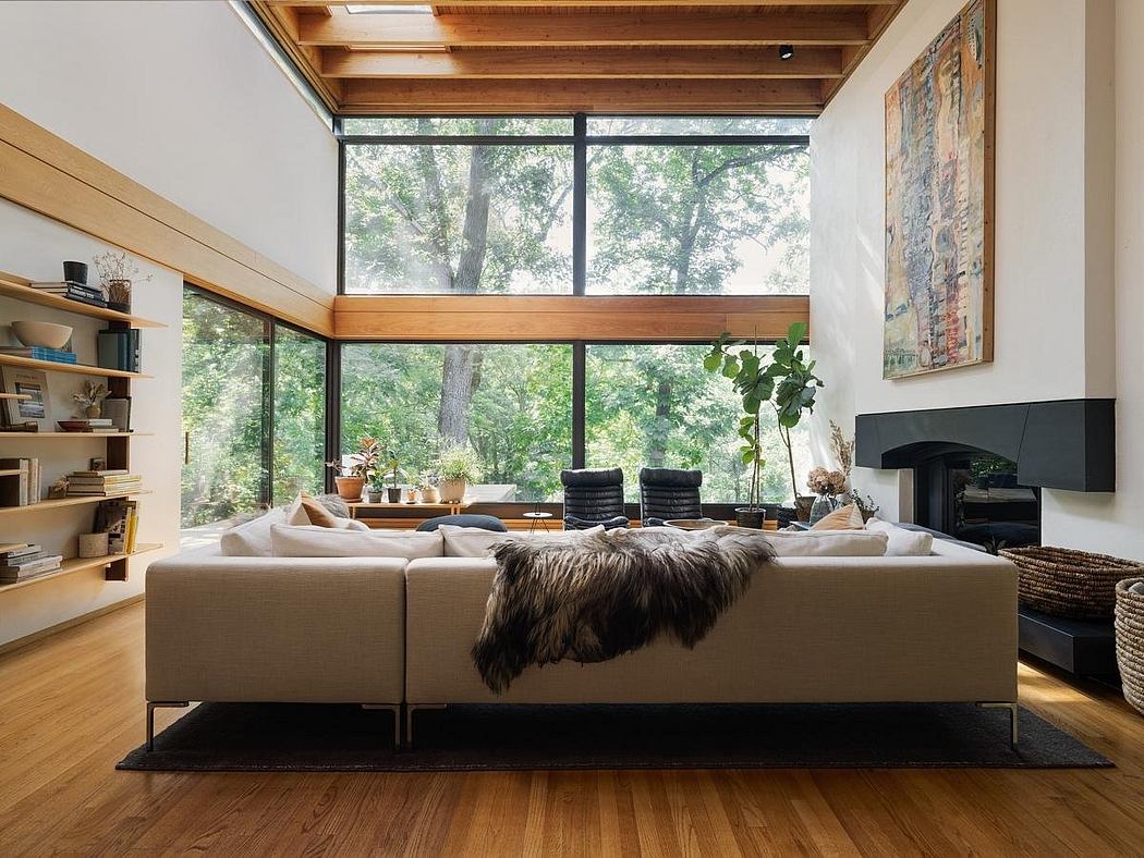 A cozy modern living space with floor-to-ceiling windows offering a serene forest view.