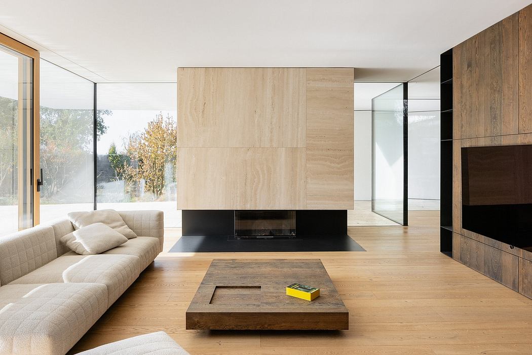 Minimalist living room with sleek fireplace, wooden accents, and large windows overlooking nature.