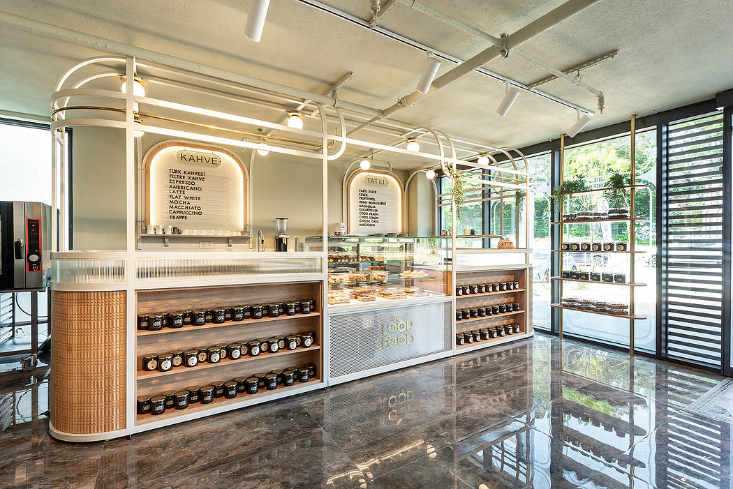 A modern, stylish cafe interior with sleek counter displays and overhead lighting fixtures.