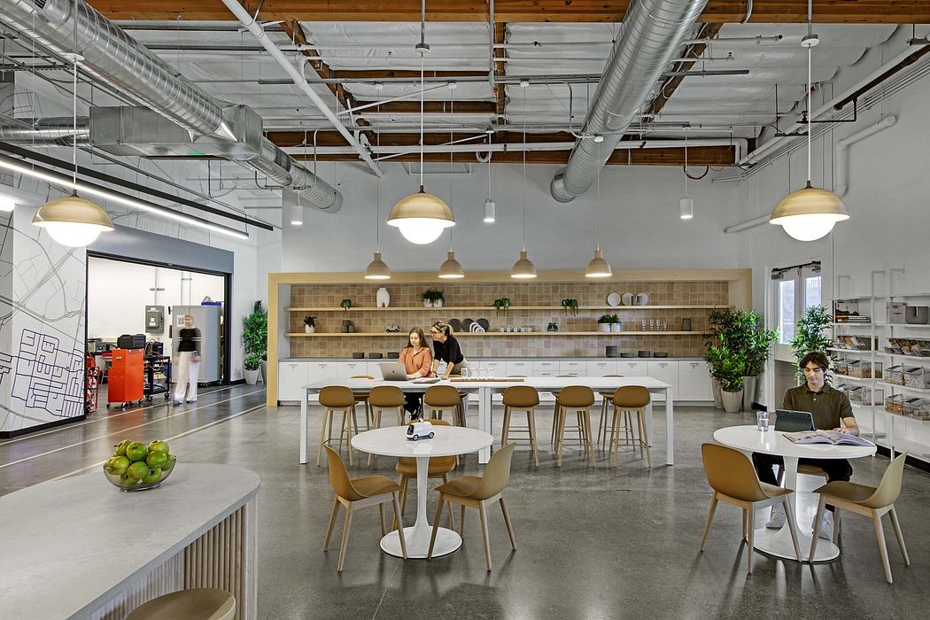 A modern, open-concept workspace with exposed industrial elements, wood accents, and functional seating.