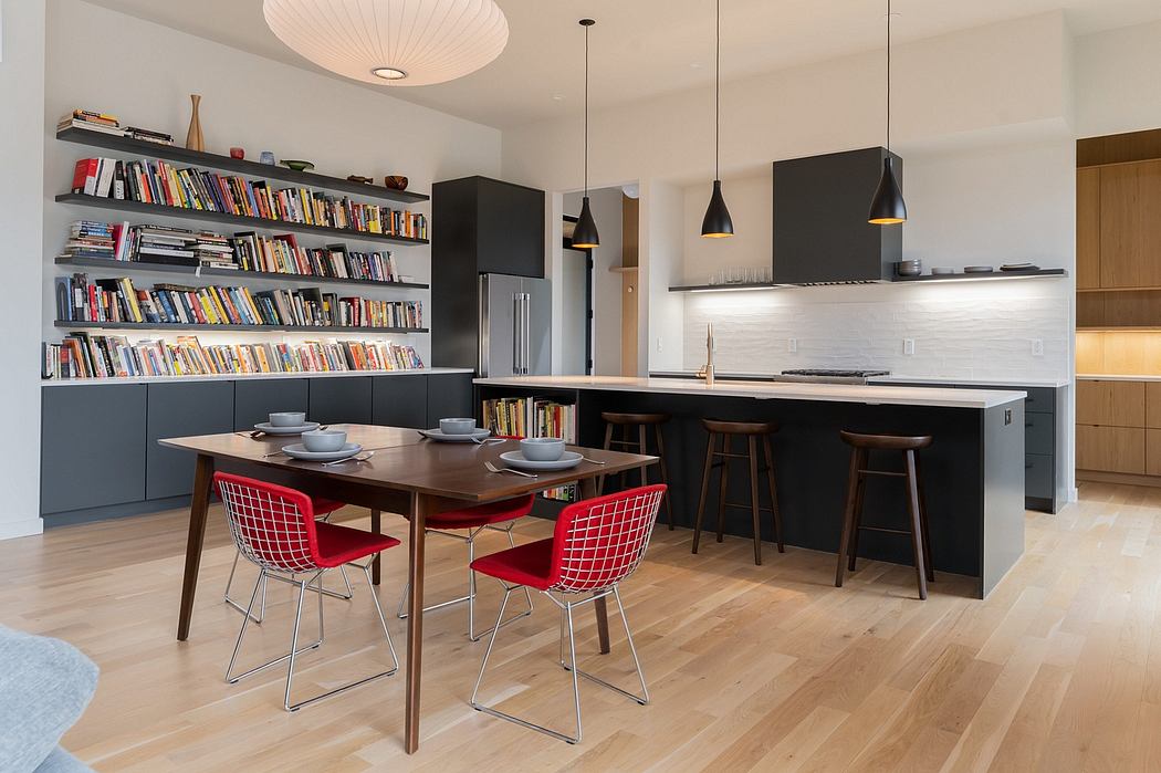 Sleek modern kitchen with open shelving, dark cabinetry, and bright red dining chairs.
