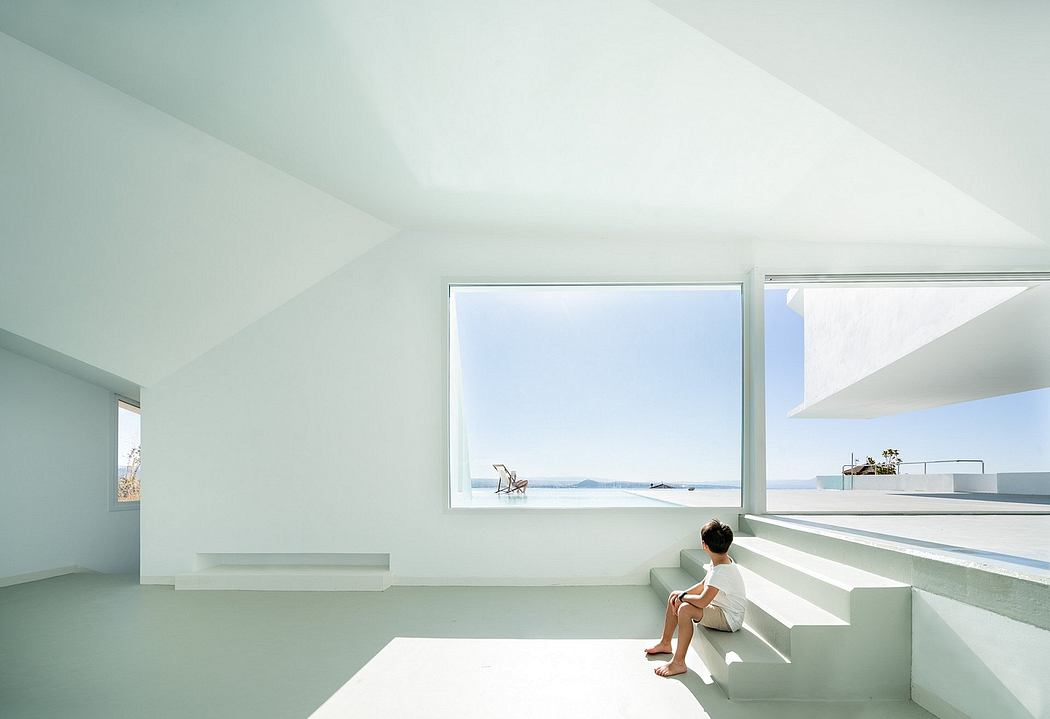 Minimalist interior with an expansive ocean view through a large window, complemented by sleek architectural details.