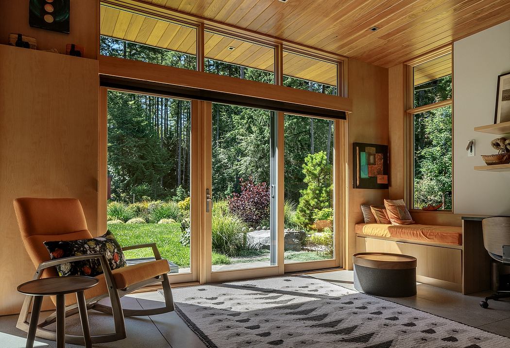 Warm, rustic interior with large windows overlooking a lush, forested landscape.