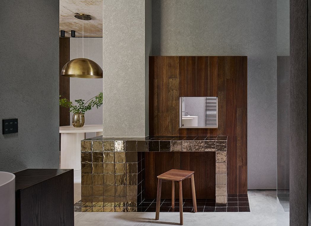 A modern, minimalist interior with a warm, wooden accent wall and a decorative brass light.