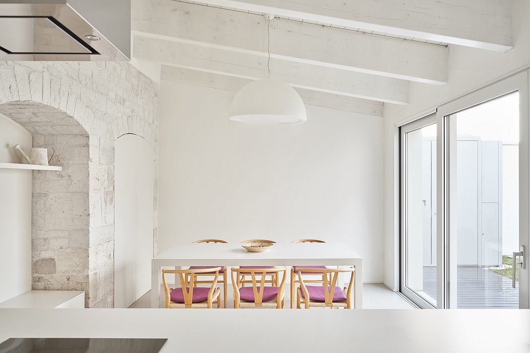 Minimalist dining room with exposed brick walls, wooden furniture, and pendant lighting.