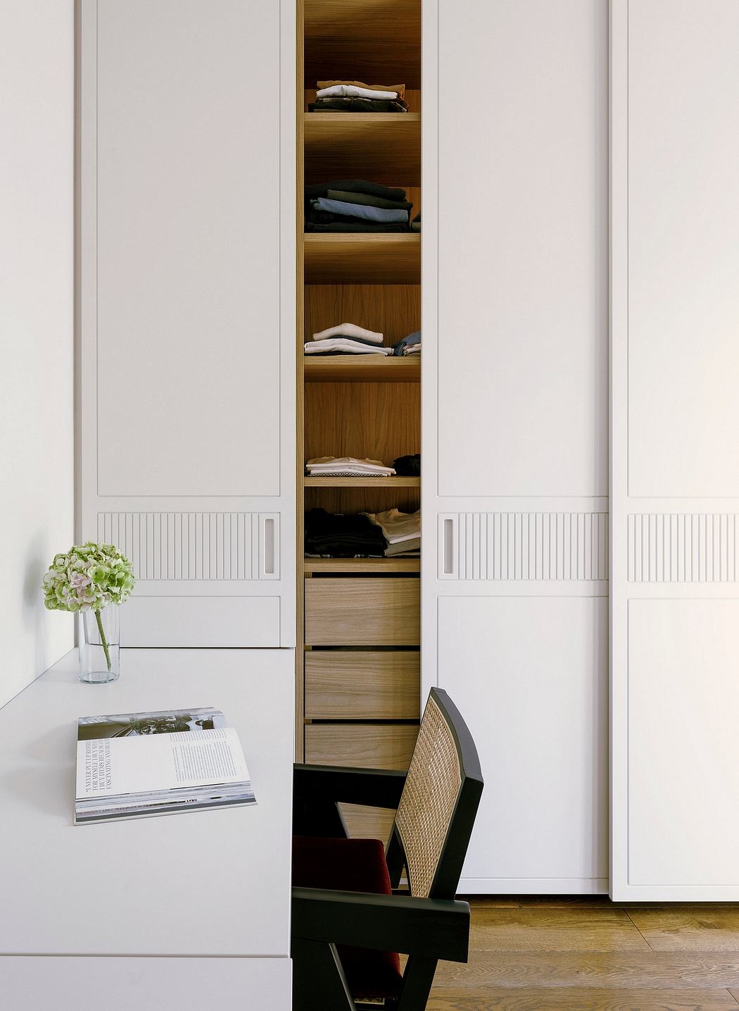 A modern, minimalist closet system with wooden shelves and storage drawers.