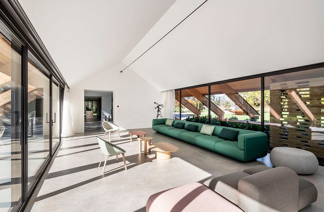 Spacious modern living room with large windows, green sofa, and wood-beam ceiling.