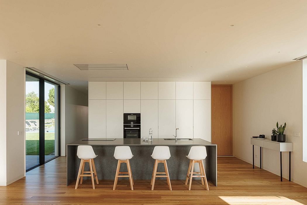 Sleek modern kitchen with minimalist cabinetry, concrete countertop, and wooden floors.