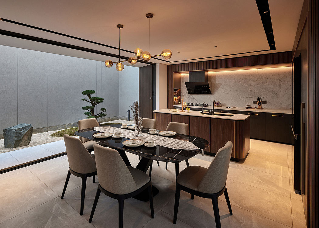 Luxurious open-plan kitchen and dining area with modern lighting and sleek furnishings.