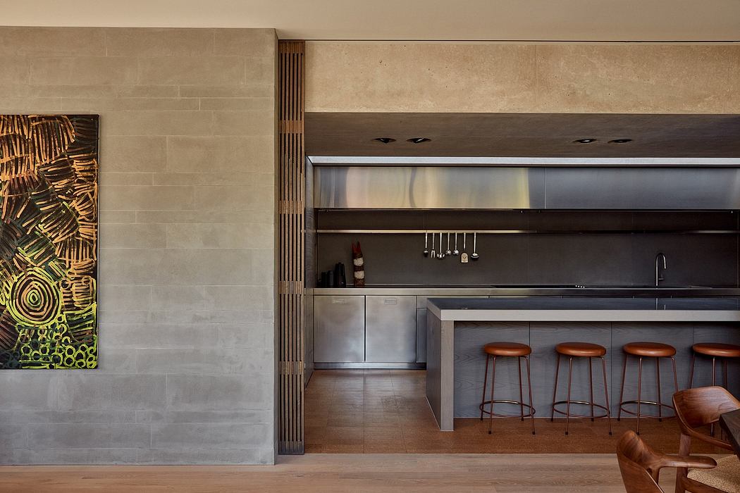 Contemporary kitchen with sleek cabinetry, wooden bar stools, and textured wall panels.