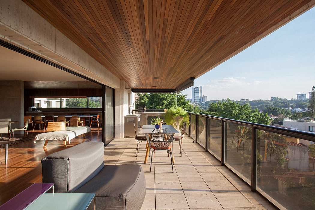 Expansive wooden-paneled patio with modern furniture overlooking lush cityscape.