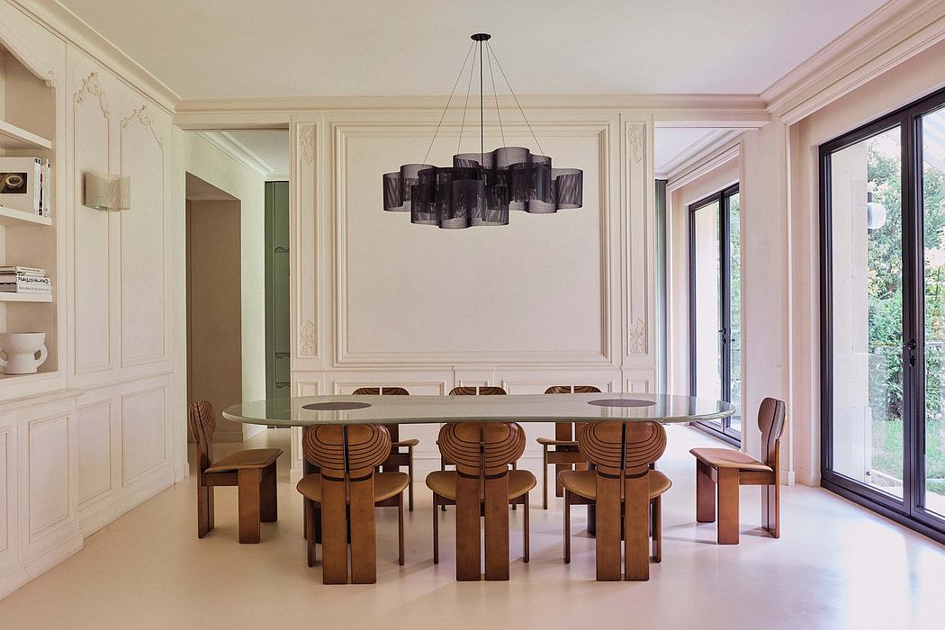 Modern dining room with ornate wall panels, large circular chandelier, and wooden furnishings.