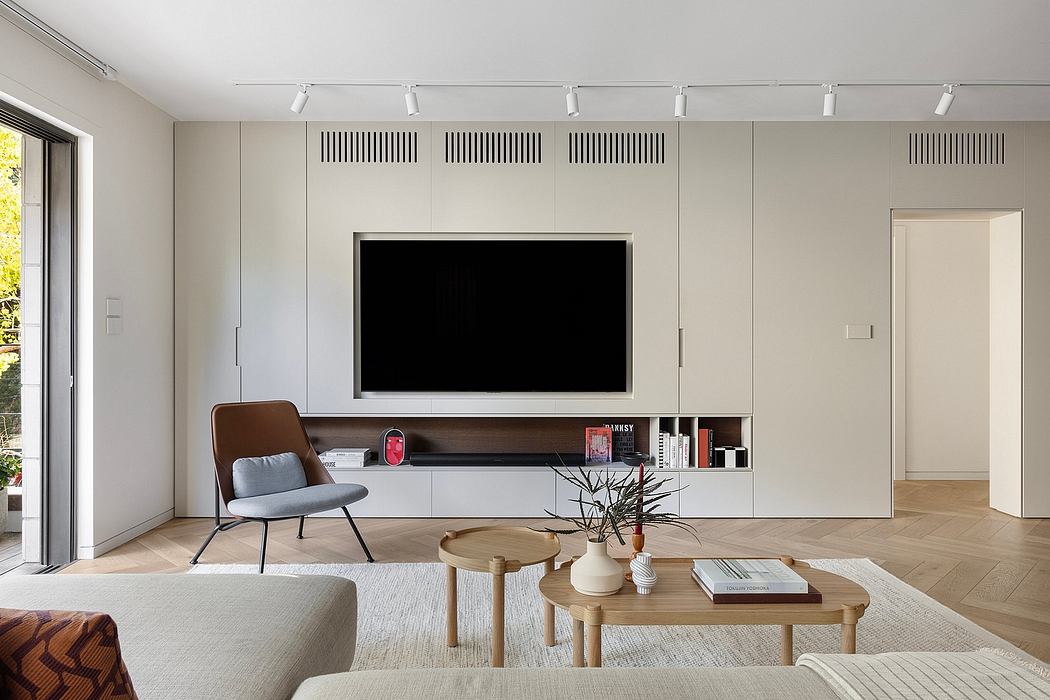 Sleek, minimalist living room with built-in TV display, neutral colors, and modern furniture.